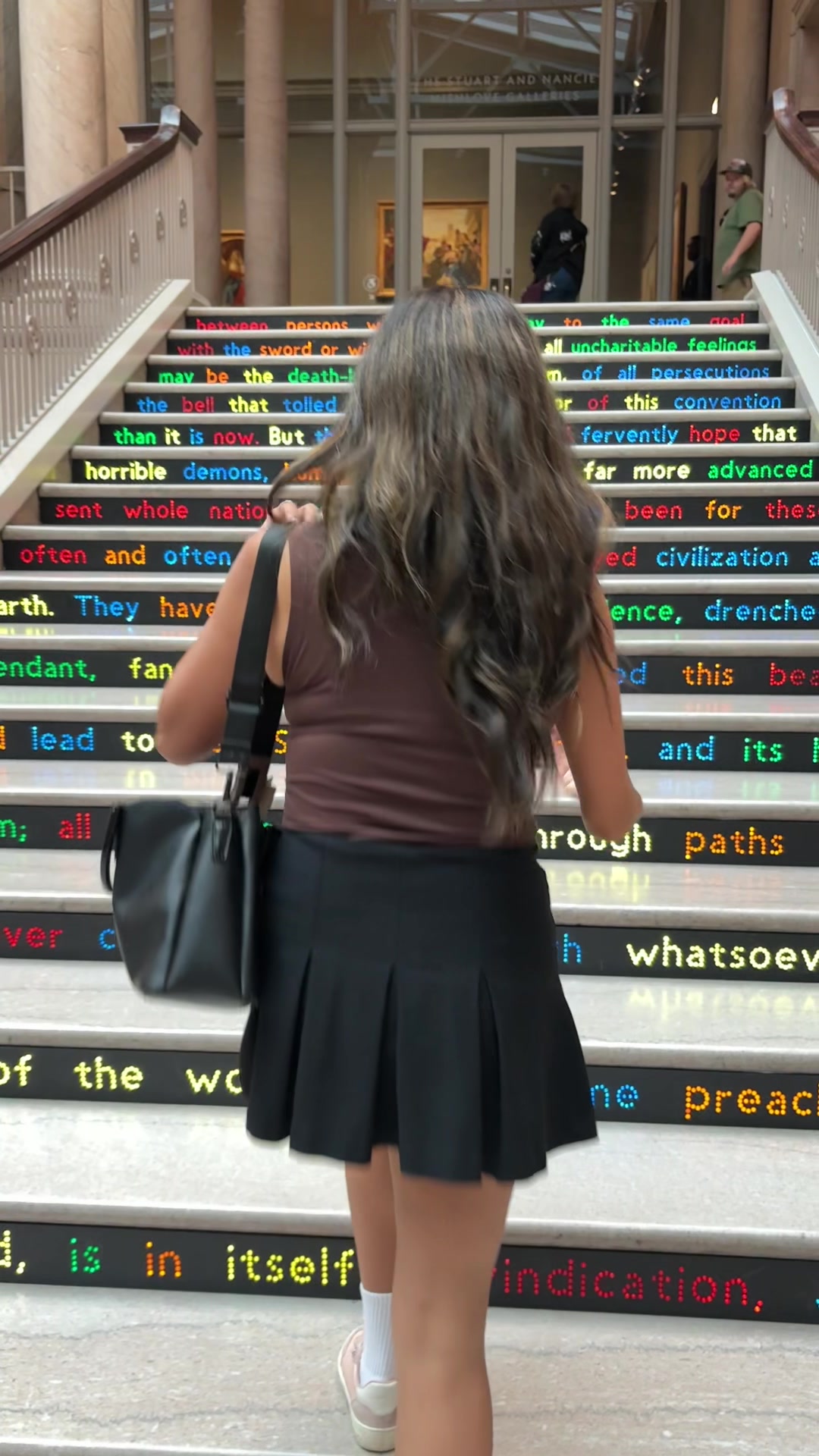 Girl walking up colorful stairs