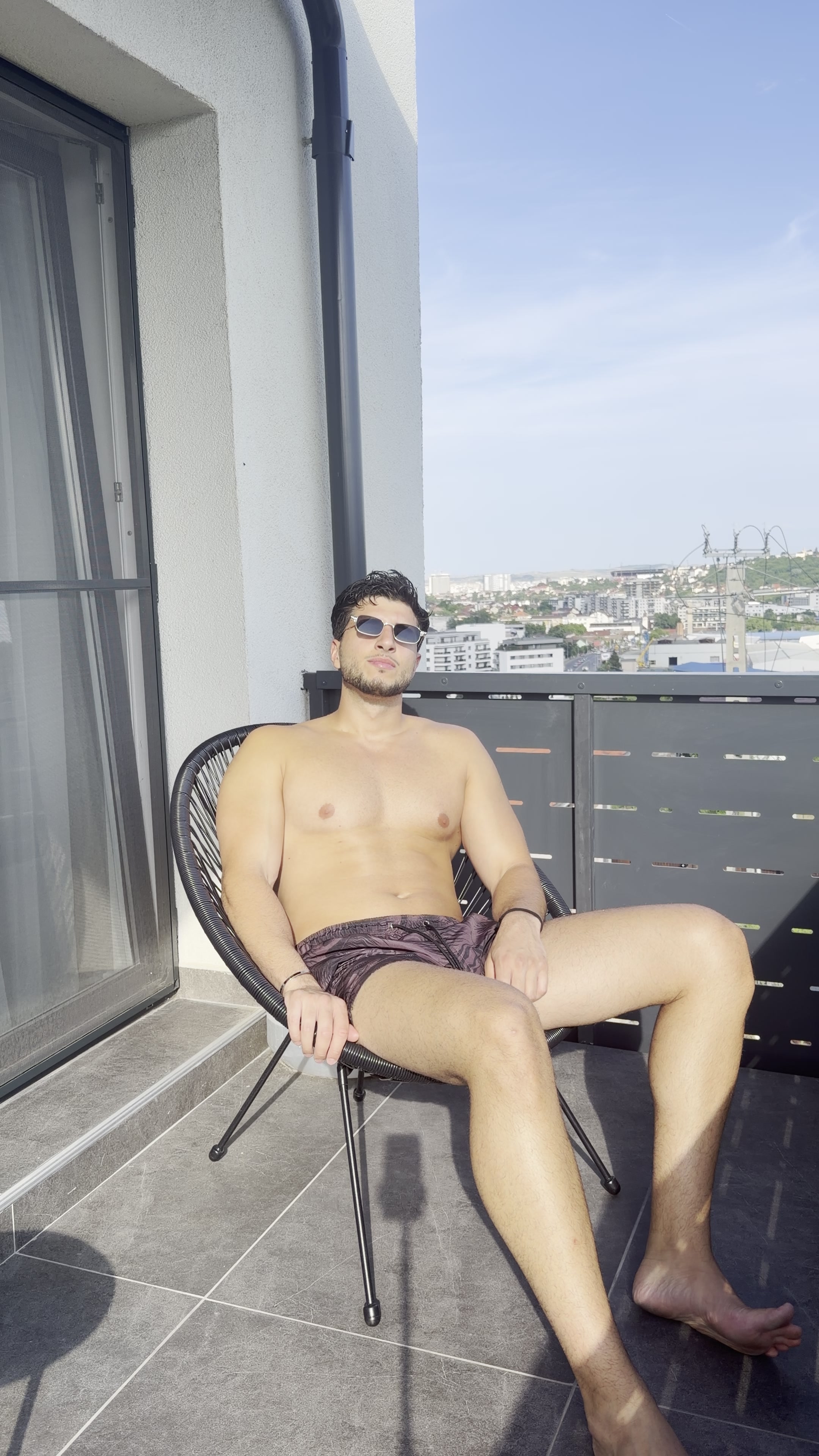 Confident Man Relaxes on Balcony
