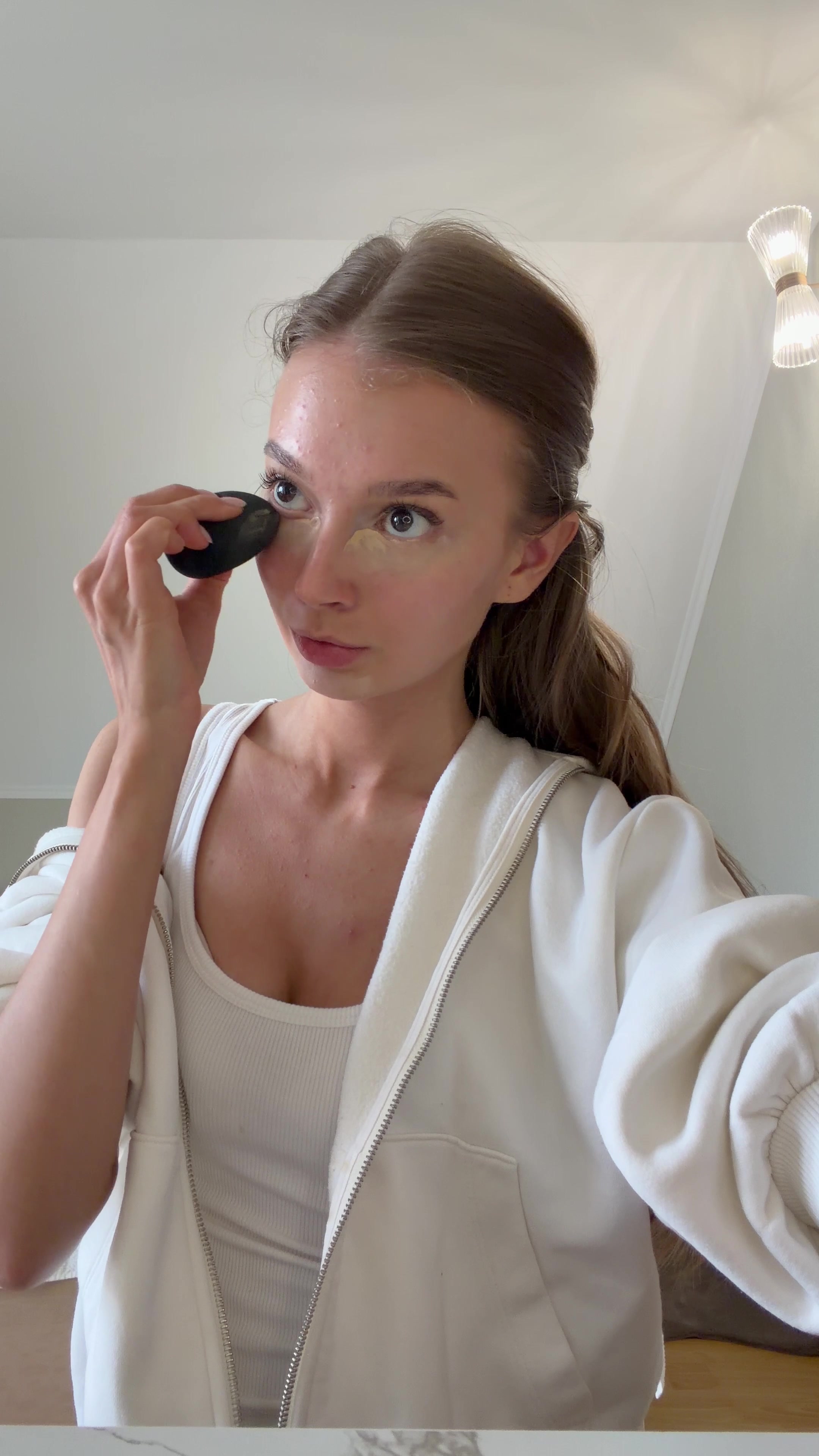 Focused Woman Applying Under-Eye Concealer