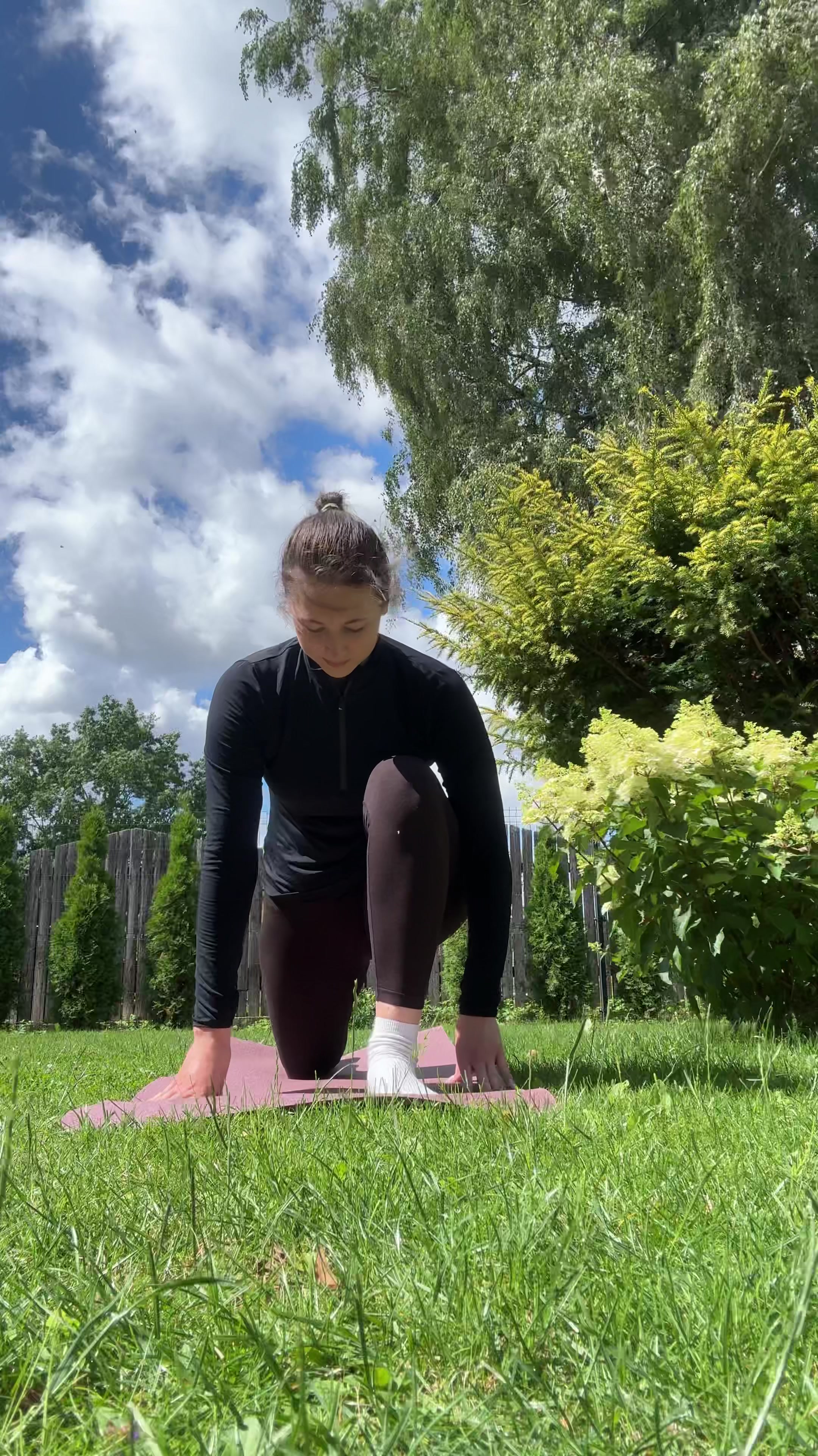 Paula stretches outdoors on yoga mat